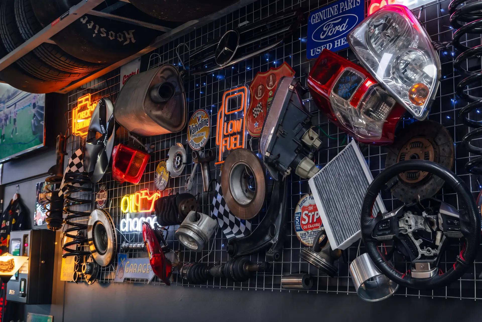 Wall of car parts, headlights, grilles and neon signs over the pool tables